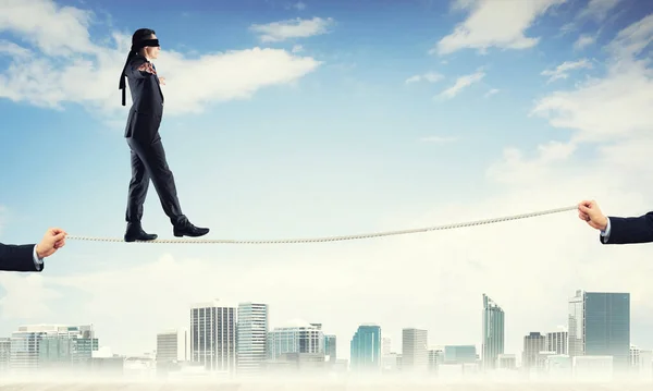 Business concept of risk support and assistance with man balancing on rope — Stock Photo, Image