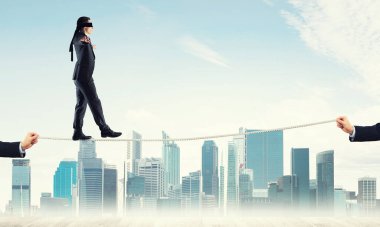 İş konsepti risk desteği ve ipte dengede duran adama yardım