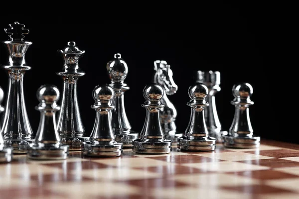 Silbrige Schachfiguren stehen auf dem Schachbrett — Stockfoto
