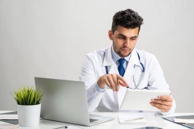 Genç Arap dahiliyeci tablet bilgisayarla çalışıyor.