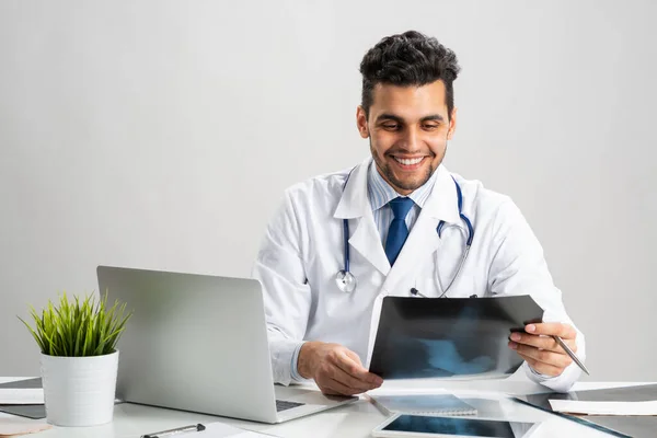 Schöne junge Ärztin schaut sich Röntgenbild an — Stockfoto