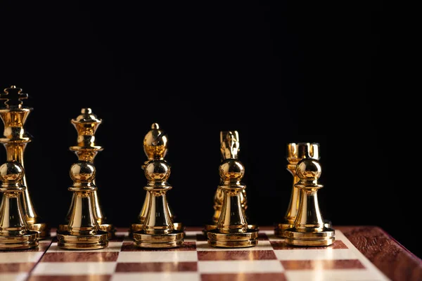 Złote figury szachowe stojące na szachownicy — Zdjęcie stockowe