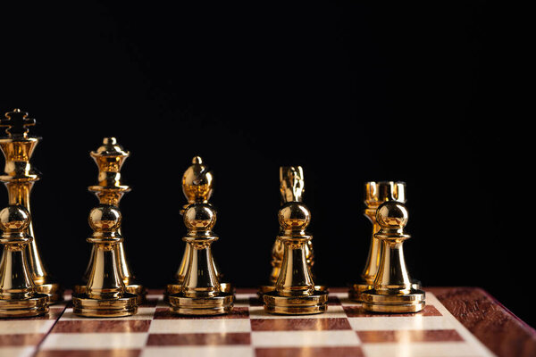 Golden chess figures standing on chessboard
