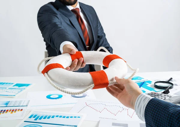 Business persons holding small lifebuoy together — Stock Photo, Image