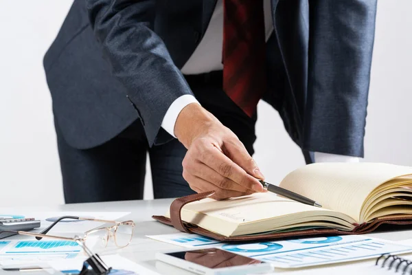 Zakenman die financiële documenten aan de balie analyseert — Stockfoto