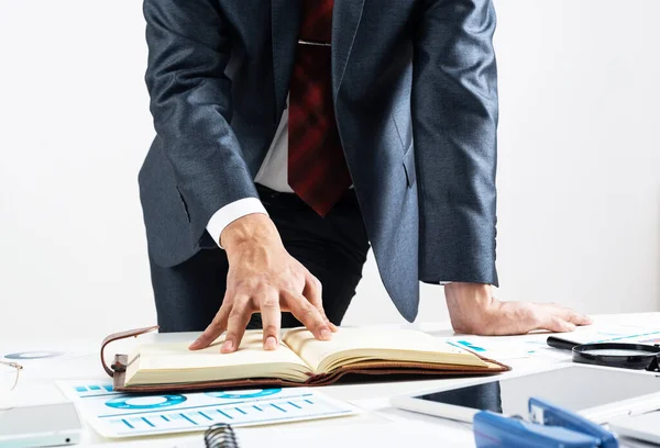 Geschäftsmann analysiert Finanzunterlagen am Schreibtisch — Stockfoto