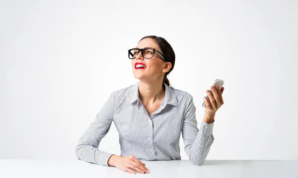 Smiling young woman sits at desk — Stock Photo, Image