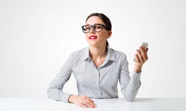 Gülümseyen genç kadın masada oturuyor.