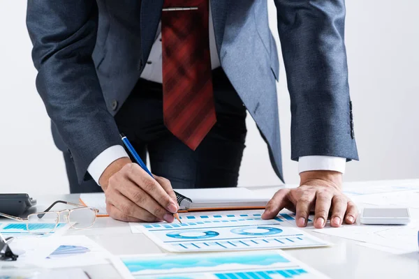 Affärsman står nära kontorsbord med penna — Stockfoto