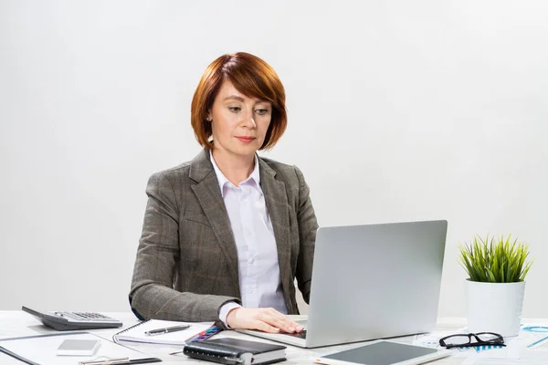Занятая взрослая деловая женщина, работающая с компьютером — стоковое фото