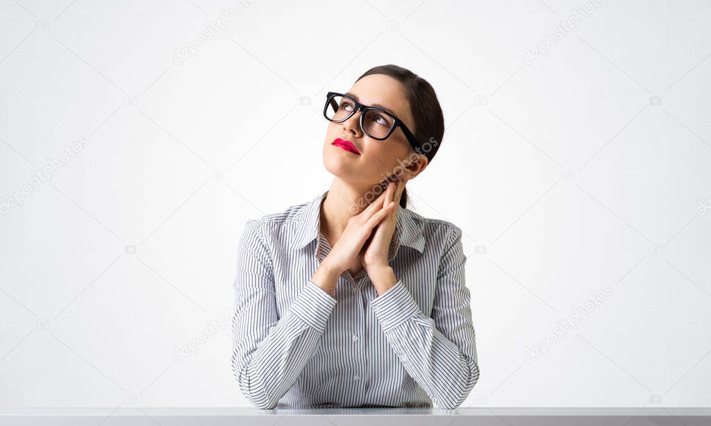 Charming young woman sits at desk