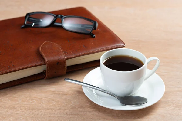 Brown leather notebook and glasses on table — Stock Photo, Image