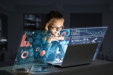 Dizüstü bilgisayarla çalışan güzel bir sarışın ve ekran dışında bilgi veren biri. Karışık ortam