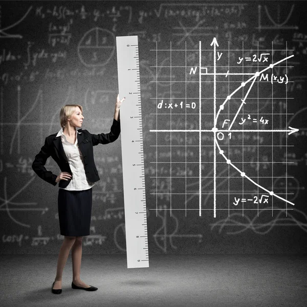 Young mathematics teacher holding big ruler — Stock Photo, Image