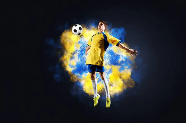 Fotbollsspelare hoppar med boll i rök — Stockfoto