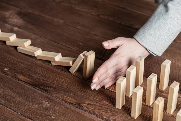 Podnikatelka chránící domino před pádem — Stock fotografie