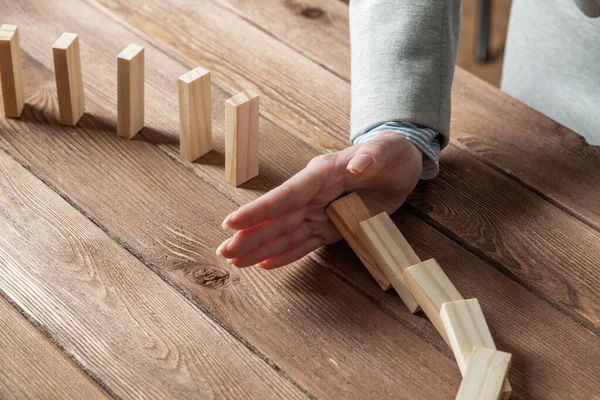 Empresária protegendo dominós de queda — Fotografia de Stock