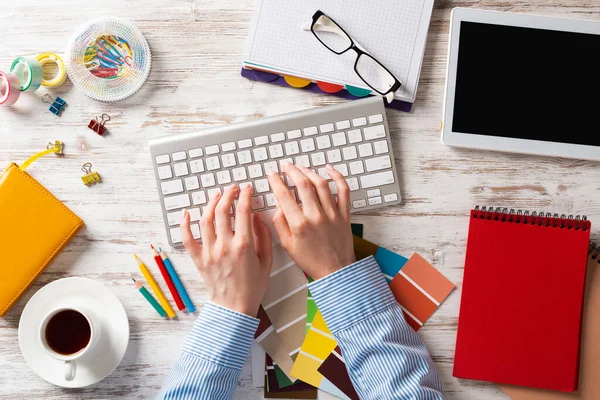 Woman designer typing on keyboard