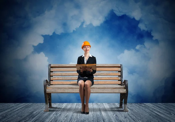 Krásná žena architekt sedí na dřevěné lavičce — Stock fotografie