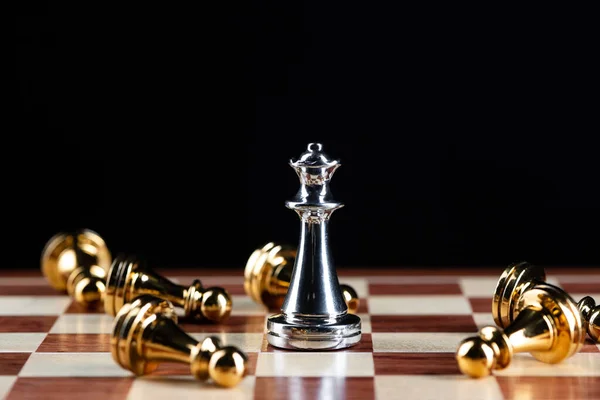 Zilveren koningin schaak verslaat gouden pionnen aan boord. — Stockfoto