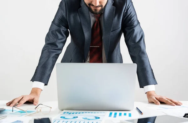 Empresario en traje y corbata de pie cerca del escritorio — Foto de Stock