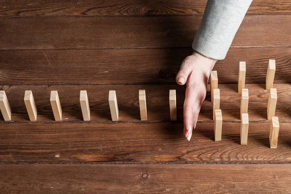 Businesswoman protecting dominoes from falling — Stock Photo, Image