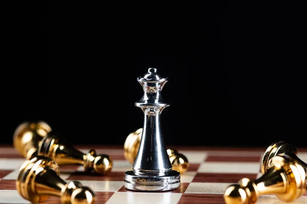 Prata rainha xadrez derrota peões de ouro a bordo. — Fotografia de Stock