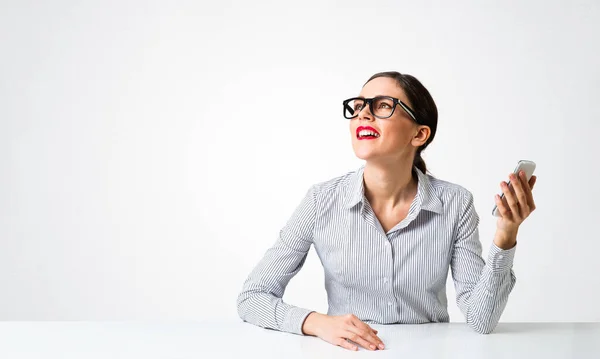 Glimlachende jonge vrouw zit aan het bureau — Stockfoto