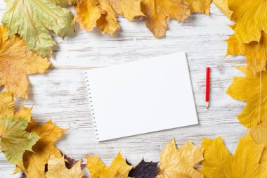 Tahta masadaki spiral çizim defteri ve kalem.