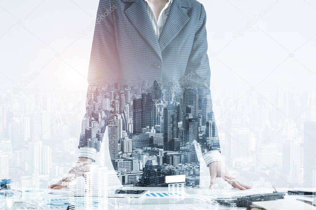 Businesswoman in suit standing near office desk