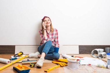 Hayalperest kız yerde akıllı telefondan konuşuyor.