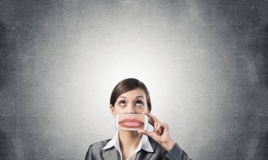 Ağzını akıllı telefonla kapatan kadın.