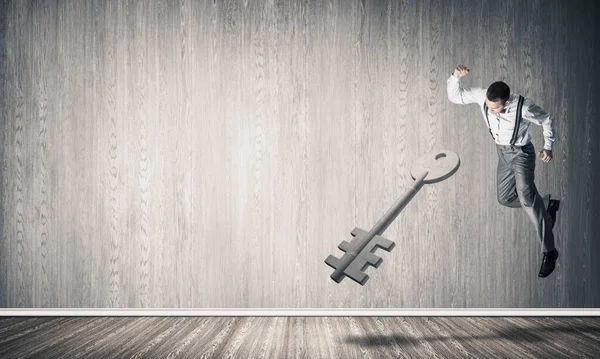 Doorbraak toegangsconcept met man in kamer verpletterende betonnen sleutel — Stockfoto
