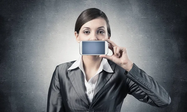 Frau verdeckt ihren Mund mit Smartphone — Stockfoto