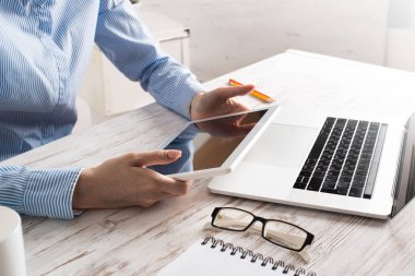 Masada tablet bilgisayar kullanan bir iş kadını.