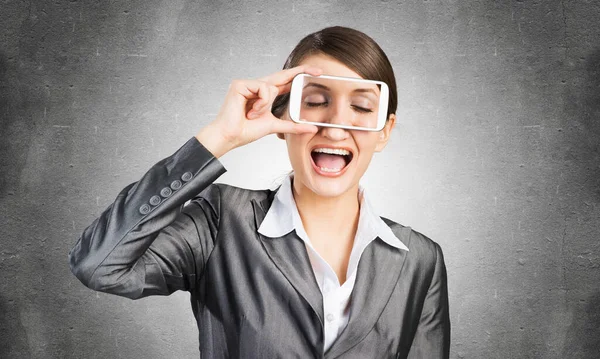 Frau verdeckt ihre Augen mit Smartphone — Stockfoto