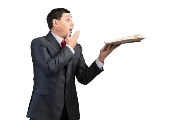 Surprised businessman holding open book — Stock Photo, Image