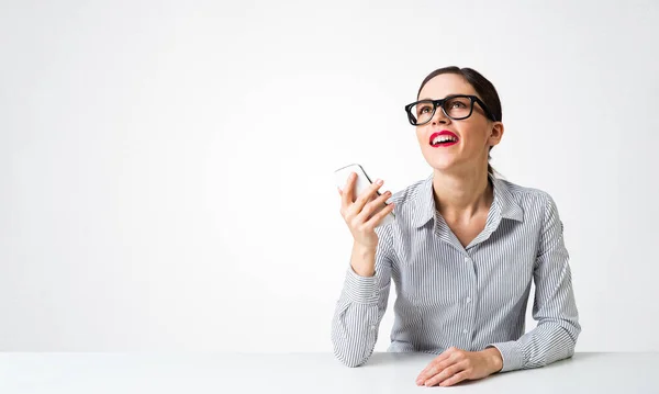 Smiling young woman sits at desk — Stock Photo, Image