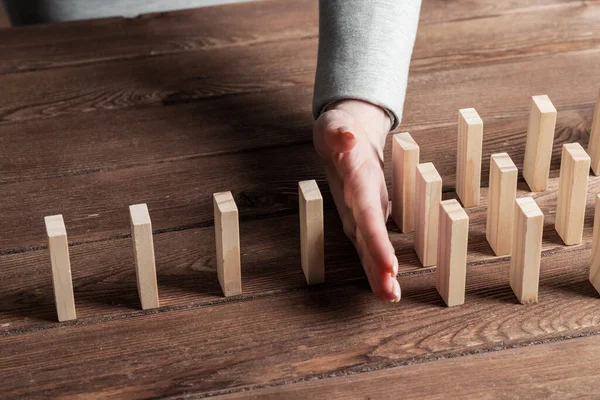 Podnikatelka chránící domino před pádem — Stock fotografie