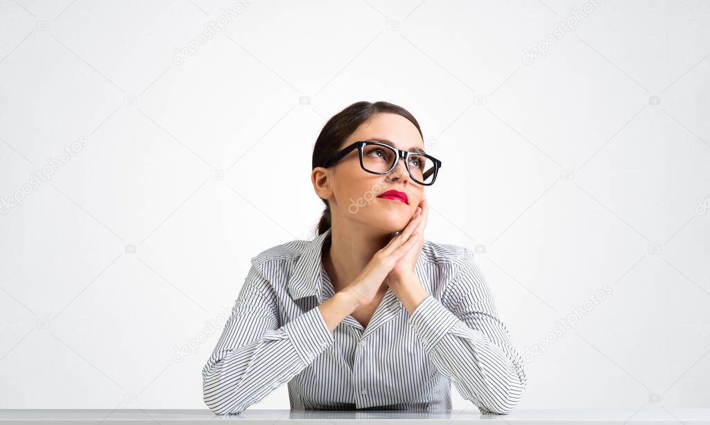 Charming young woman sits at desk