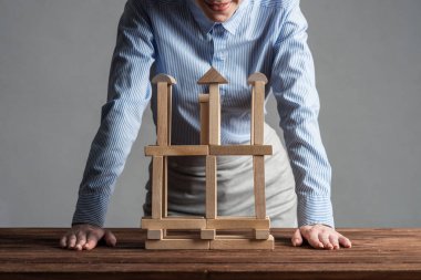 İş kadını ahşap bloklardan masa üzerine inşaat yapıyor. Mimarlık mühendisliği ve inşaat. Şirket stratejisi, organizasyon ve geliştirme. İş motivasyonu kavramı