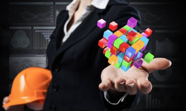 İş kadını avuç içi soyut 3D küp modelini tutuyor. Turuncu kasklı, takım elbiseli kadın mühendis. Tam çözüm ve modern dijital teknoloji. Mimarlık ve inşaat şirketi