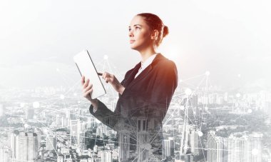 Tablet bilgisayar kullanan genç bir iş kadını. Modern şehir manzarası ve takım elbiseli güzel bir kadınla çift pozlama konsepti. Emlak yönetimi ve geliştirme şirketinde dijital teknoloji.