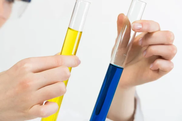 臨床研究室分析と検査 コロナウイルス病の検査 カラー液体で試験管を保持している女性の手を閉じます 試験管内の生物試料を比較する実験室アシスタント — ストック写真