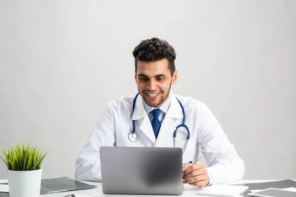 Νεαρός Άραβας Παθολόγος Που Δουλεύει Στον Υπολογιστή Χαμογελαστή Ιατρός Λευκό — Φωτογραφία Αρχείου