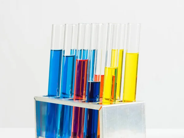 Science laboratory research and development. Modern biochemistry industry mockup. Close up test tubes with color liquid on white background. Chemical manufacture concept with glass equipment.