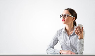 Gülümseyen genç kadın masada oturuyor.