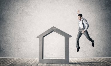 Taştan ev silueti, emlak sigortasının sembolü olarak boş odada.