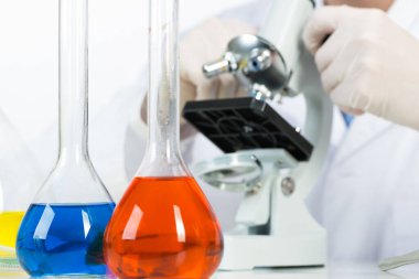 Laboratuvarda mikroskopla inceleyen bilim adamları