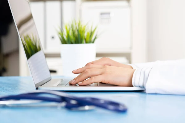 Primer plano de las manos del médico femenino usando el ordenador portátil —  Fotos de Stock